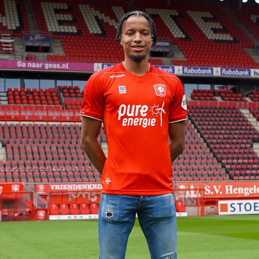 Tyronne Ebuehi poses in FC Twente's home jersey